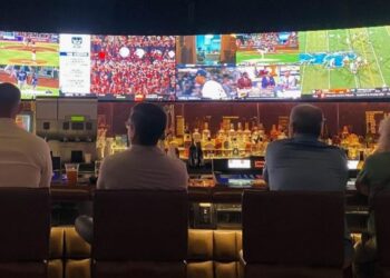 A lively pub atmosphere with people engrossed in watching sports, cheering, and enjoying the game together.