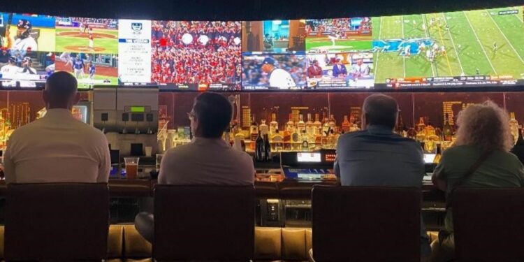A lively pub atmosphere with people engrossed in watching sports, cheering, and enjoying the game together.